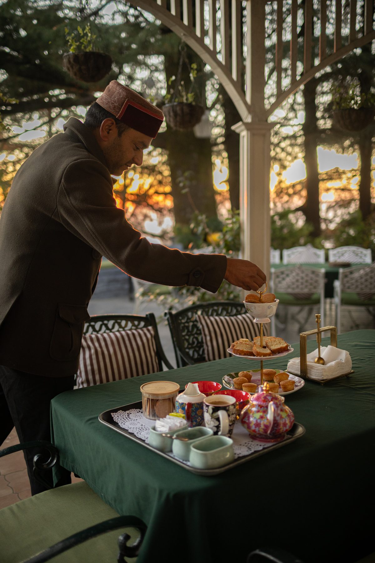 A butler arranging the tiered tea stand